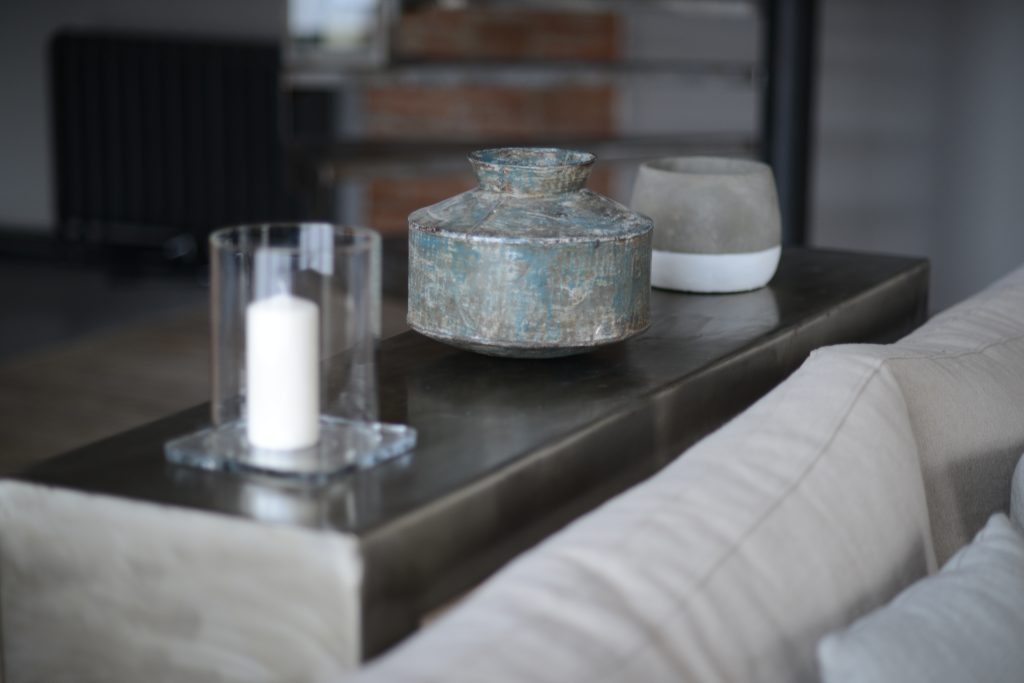 Détail de décoration minimaliste avec pot ancien et bougie, reflet du style épuré et authentique des séjours Grainedejeune.
