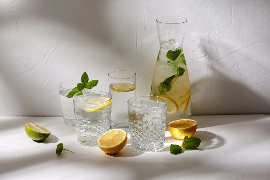 Verres d’eau citronnée et carafe garnie de feuilles de menthe, symboles de fraîcheur, de détox et d’équilibre des séjours Grainedejeune.