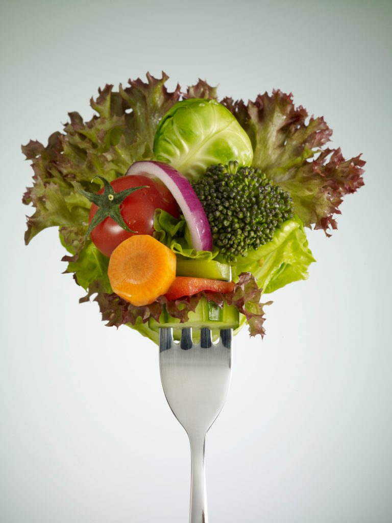 Fourchette garnie de légumes frais colorés symbolisant la vitalité, la détox et l'équilibre des séjours de jeûne haut de gamme Grainedejeune.