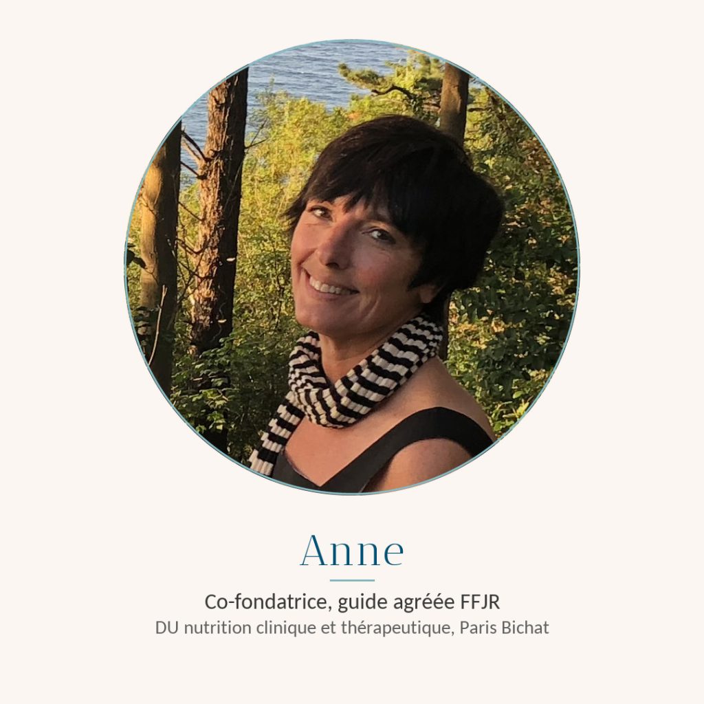 Anne De Via, co-fondatrice de Graine de Jeûne et guide certifiée FFJR, souriante dans une pinède face à la mer