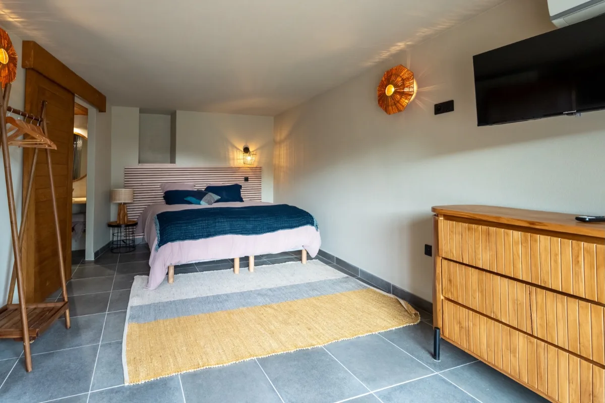 Chambre claire du lieu de séjour, lit bas et tête de lit en bois