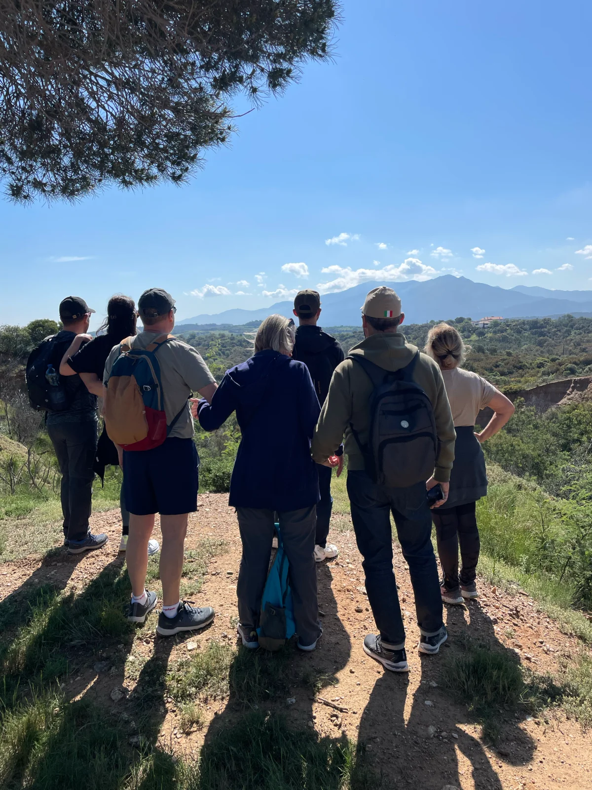 Groupe de randonneurs vus de dos sur un sentier de la forêt domaniale du Réart, à Tordères