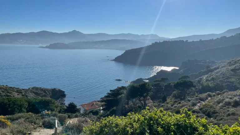 Mer calme, montagnes dans la brume au loin